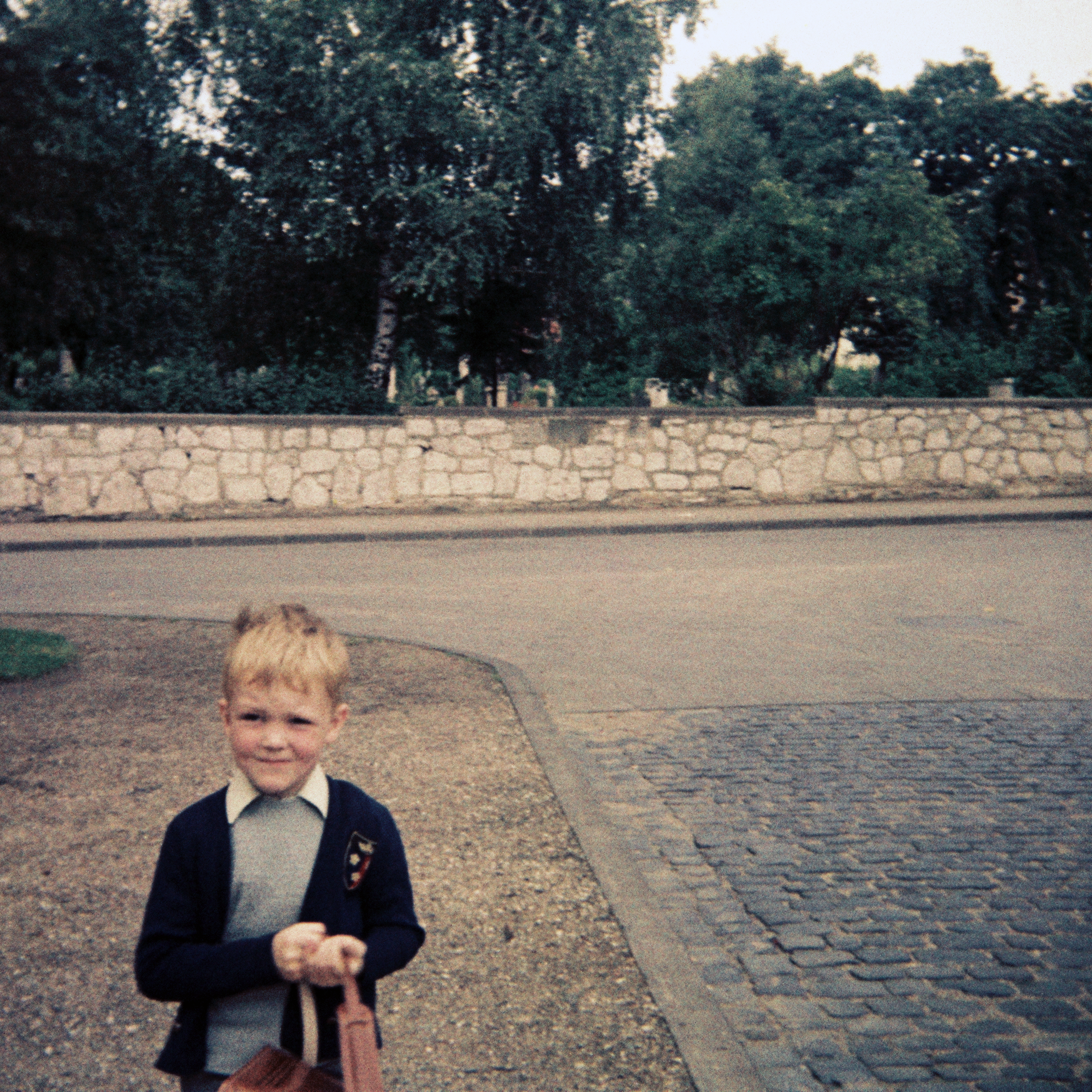 Ein Junge am Tage seiner Einschulung mit seinem Leder-Tornister in der Sprengerstraße/ Ecke Struckmannstraße in Hildesheim im Jahre 1967.