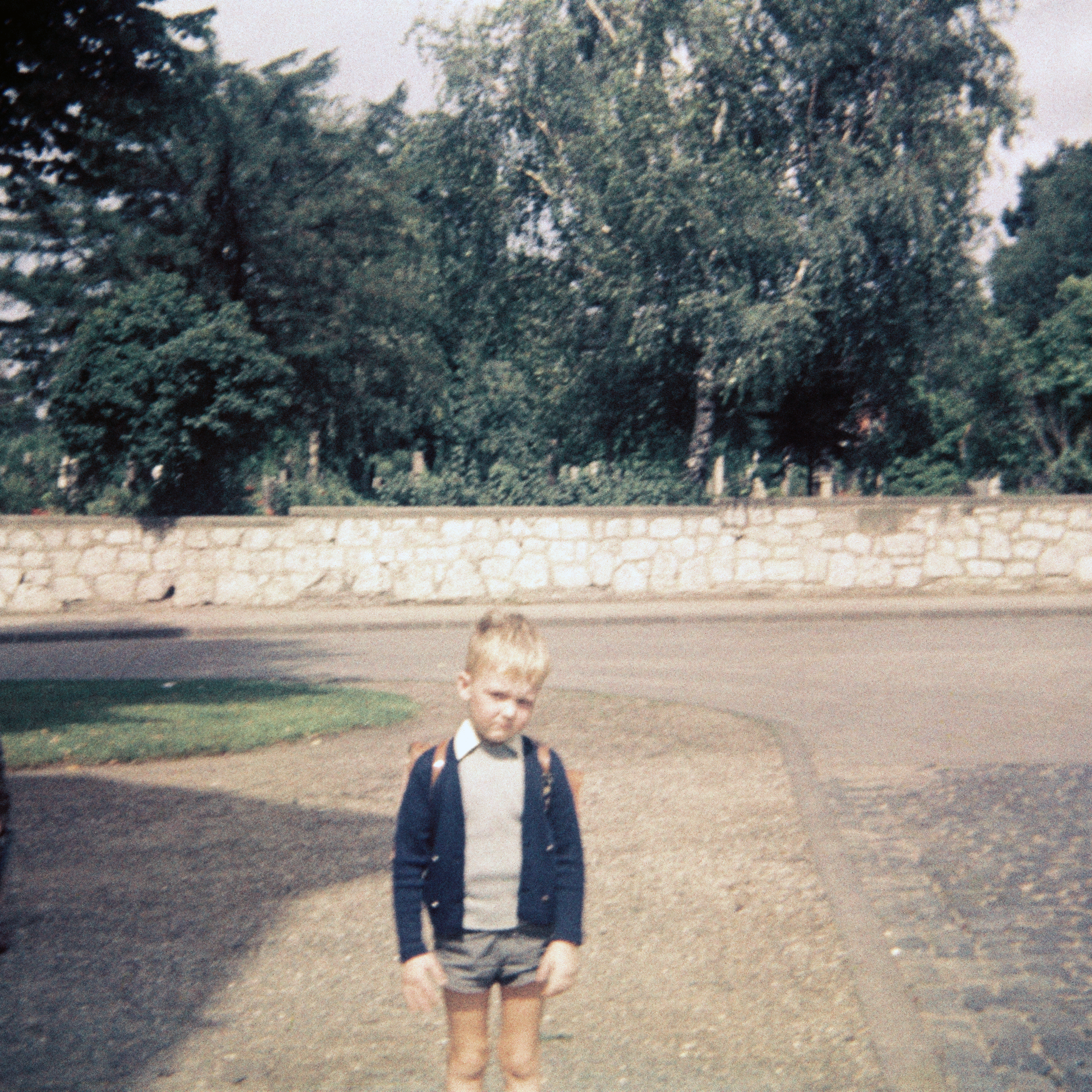 Ein Junge am Tage seiner Einschulung mit seinem Schultornister aus Leder auf dem Rücken in der Sprengerstraße/ Ecke Struckmannstraße in Hildesheim im Jahre 1967.